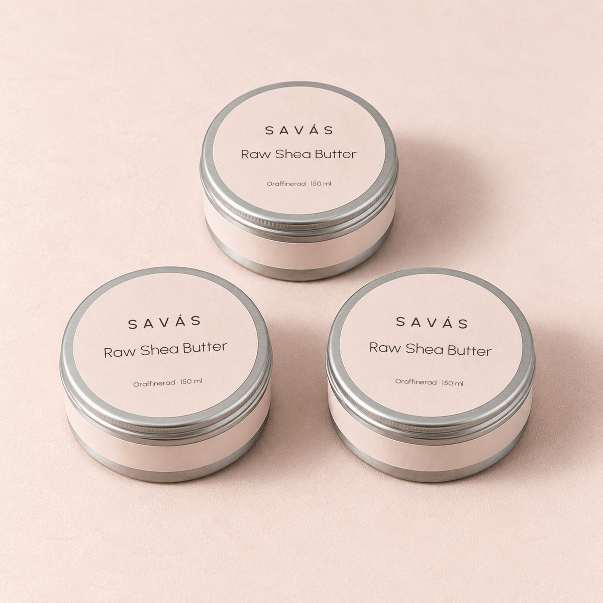 Tre stängda burkar Raw Shea Butter från SAVÁS på rosa bakgrund